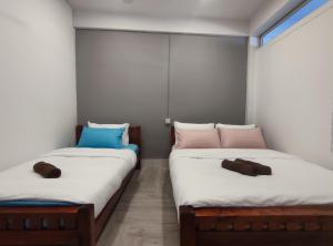 dos camas sentadas una al lado de la otra en una habitación en Zamanja Betong106 Main Street en Yala
