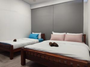 two beds in a room with shoes on them at Zamanja Betong106 Main Street in Yala