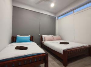 dwa łóżka siedzące obok siebie w pokoju w obiekcie Zamanja Betong106 Main Street w mieście Yala