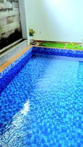 una piscina con azulejos azules encima en MG'S Villa en Batu