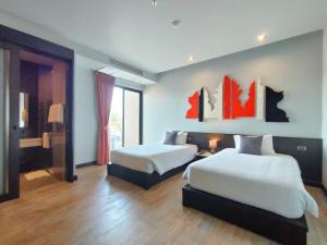 a bedroom with two beds and a large window at Sorin hotel in Surin