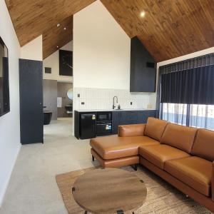 a living room with a couch and a table at Chalet Hills in Sampsons Flat