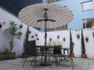 a table and chairs with an umbrella on a patio at Floralia Casa Boutique in Bogotá