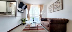 salon z brązową kanapą i oknem w obiekcie MC Suite - Sur w mieście Antofagasta