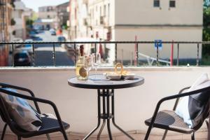 uma mesa numa varanda com 2 cadeiras e copos de vinho em [Oristano centro] Parcheggio privato, Wifi+Netflix em Oristano