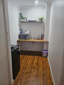 eine kleine Küche mit einem Schreibtisch und einer Mikrowelle in der Unterkunft Le Dar in Orange