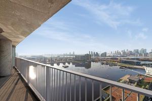 un balcone con vista sul fiume da un edificio di Excel 3 Bedroom Apartment Near City Airport and O2 Arena a Londra