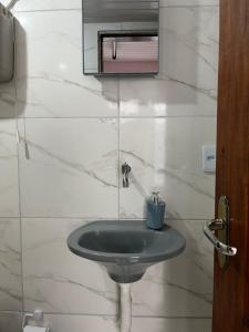 a bathroom with a green sink and a mirror at Luso Apartamentos in Manaus