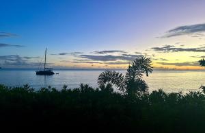 舍爾謝的住宿－LA PLAGE MARTINIQUE，日落时分在水中航行的帆船