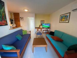 a living room with a blue couch and a table at Appartement Manganao beach in Saint-François