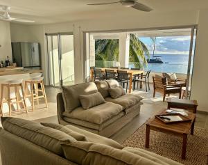 a living room with a couch and a table and a kitchen at LA PLAGE MARTINIQUE in Schœlcher