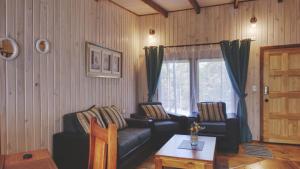 a living room with two couches and a table at Cabaña Los Coihues in Puerto Montt
