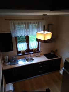 a kitchen with a sink and a window at Oaza Huzele in Hużele +5 photos