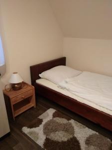 1 dormitorio con 1 cama y 1 mesa con lámpara en Oaza Huzele en Hużele