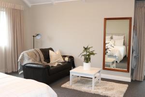 a bedroom with a mirror and a chair and a bed at St Kilda Studio in Cambridge
