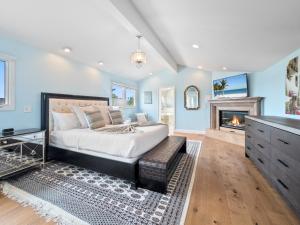 ein Schlafzimmer mit einem Bett und einem Kamin in der Unterkunft La Jolla Luxury Estate - Massive Yard, Pool-Spa, Fast WiFi & Outdoor Fireplace in San Diego