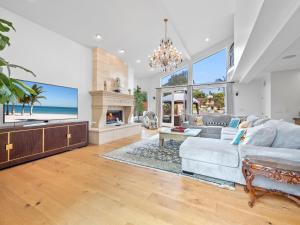 ein Wohnzimmer mit einem Sofa und einem Kamin in der Unterkunft La Jolla Luxury Estate - Massive Yard, Pool-Spa, Fast WiFi & Outdoor Fireplace in San Diego