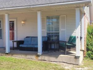 eine Veranda mit einem Sofa und einem Tisch auf einem Haus in der Unterkunft Beautiful 3 bedroom home 4 minutes from the beach in Pensacola