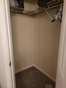 a closet with a white wall and a shelf at Beautiful 3 bedroom home 4 minutes from the beach in Pensacola