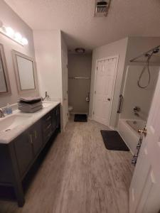 a bathroom with a sink and a tub and a toilet at Beautiful 3 bedroom home 4 minutes from the beach in Pensacola