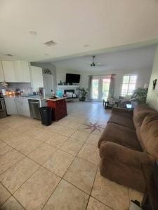 a living room with a couch and a kitchen at Beautiful 3 bedroom home 4 minutes from the beach in Pensacola