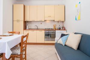 uma cozinha com uma mesa e um sofá azul em [Oristano centro] Parcheggio privato, Wifi+Netflix em Oristano