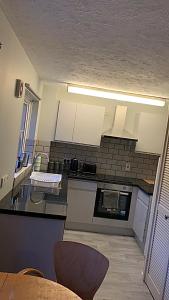 una cocina con encimeras blancas y negras y armarios blancos en Southampton centre - 1 bed studio flat en Southampton