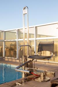 a chair sitting next to a pool on a building at Flat Tatuapé Sua Casa Your Home in São Paulo