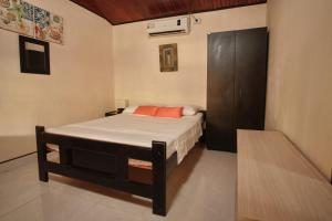 1 dormitorio con 1 cama y armario de madera en Apartamentos Turísticos Casa Manuela, en San Andrés