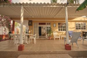 un patio con sillas, mesa y toldo en Apartamentos Turísticos Casa Manuela, en San Andrés