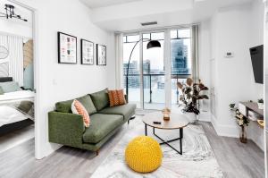 ein Wohnzimmer mit einem grünen Sofa und einem Tisch in der Unterkunft Stylish Suite at 300 Front Street W in Toronto