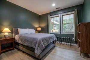 sypialnia z zielonymi ścianami, łóżkiem i oknem w obiekcie The Lazy Tiger Hostel w mieście Woodfin