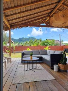 - un patio avec un canapé et une table sur une terrasse en bois dans l'établissement ANAA Villa - Tropical experience, à Atiha