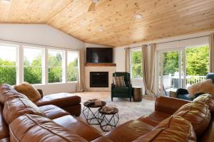 a living room with a leather couch and chairs at Luxurious 5BR w/ Hot Tub, Close to Loon Mountain in Campton