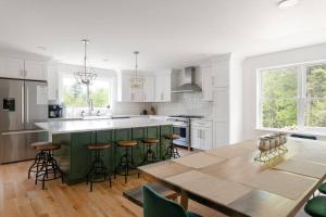a kitchen with a wooden table and a green island at Luxurious 5BR w/ Hot Tub, Close to Loon Mountain in Campton