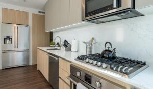 a kitchen with a stove top oven next to a refrigerator at Stylish Condo By The Beach in Los Angeles