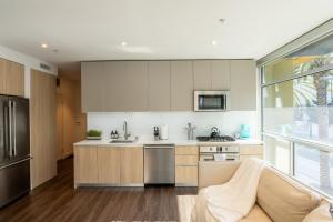a kitchen with white cabinets and a large window at Stylish Condo By The Beach in Los Angeles