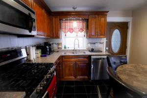 a kitchen with wooden cabinets and a stove and a sink at Mount Pleasant Hideaway in Providence