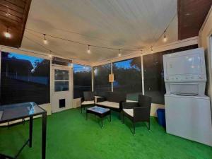 Una sala de estar con suelo verde y un televisor de pantalla grande. en Sunset on the Gulf, en Hudson