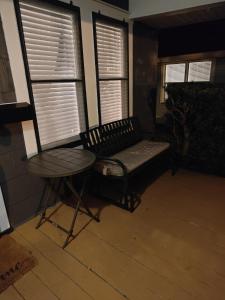 un banco y una mesa en una habitación con ventanas en Beautiful Mid Century Bungalow In The Heart of Lakeland, en Lakeland
