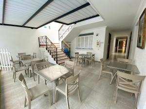 un restaurante con mesas y sillas y una escalera en Hotel San Julian, en Buga