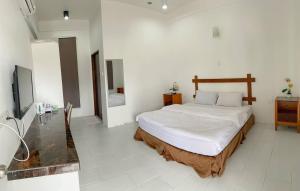 1 dormitorio con 1 cama y TV en Fikri Wetland Guesthouse & Resort, 