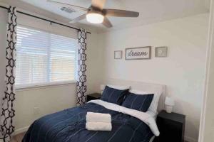 Schlafzimmer mit einem blauen Bett und einem Deckenventilator in der Unterkunft Entire residential home - 1 story, 3 beds, 2 baths in Houston