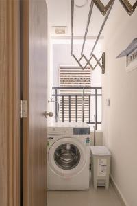 una lavadora en una habitación con ventana en Roomio De Capella - Share Apartment, en Ho Chi Minh
