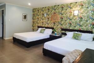 two beds in a room with a wall mural at RedDoorz @ Padi Beach Resort Oton Iloilo in Oton