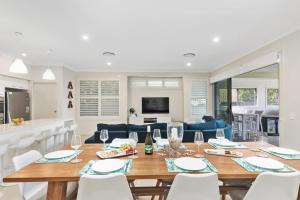 een eetkamer en een woonkamer met een tafel en stoelen bij Coastal Palms Escape - Your Ideal Family Getaway in Barrack Point