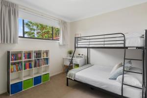 een slaapkamer met een stapelbed en een raam bij Coastal Palms Escape - Your Ideal Family Getaway in Barrack Point