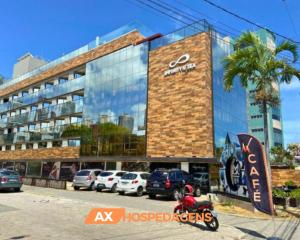 un gran edificio con coches estacionados frente a él en AX Infinity At The Sea, en João Pessoa