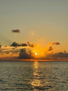 a sunset over the ocean with the sun setting at POSADA MISS ANIBEL in La Loma