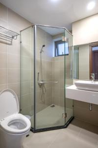 uma casa de banho com um chuveiro, um WC e um lavatório. em Roomio De Capella - Share Apartment em Ho Chi Minh